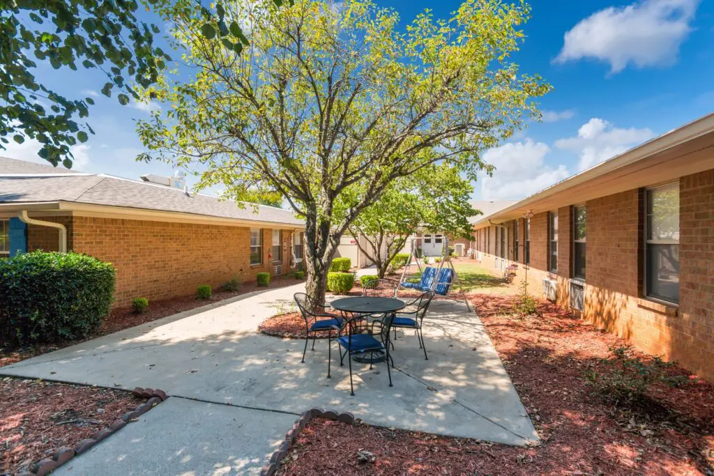 Outdoor courtyard area with tables and chairs and multiple shade trees