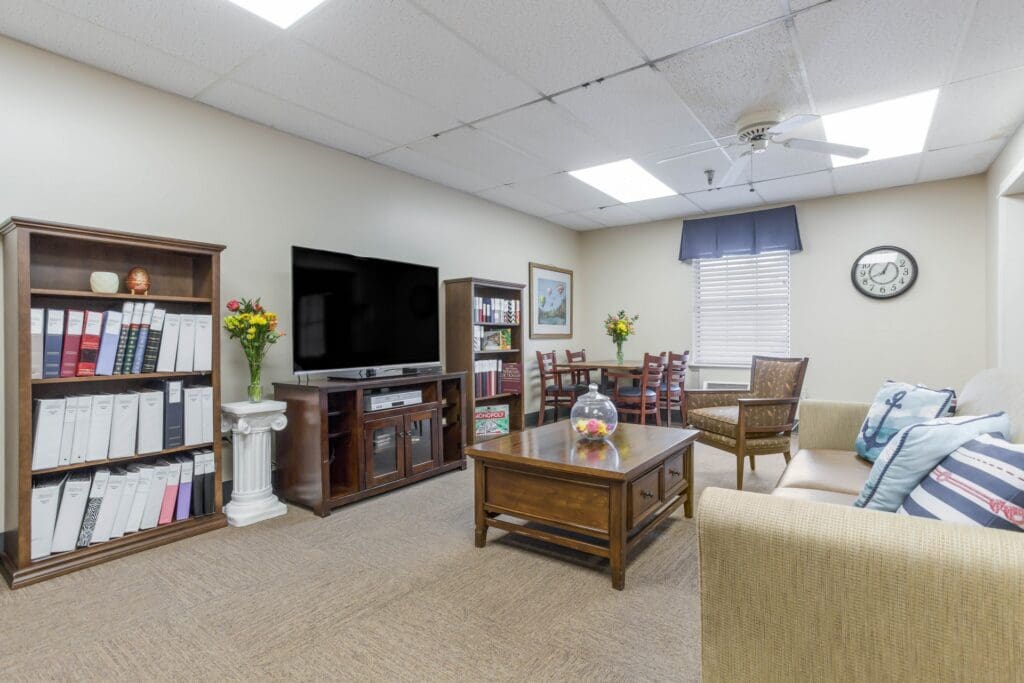 Sitting area featuring sofa, television, bookshelf, coffee table, table and chairs set, and various decor